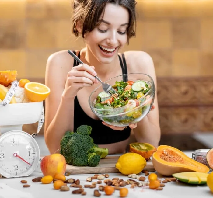 Woman enjoying a fresh, balanced meal of vegetables and fruit